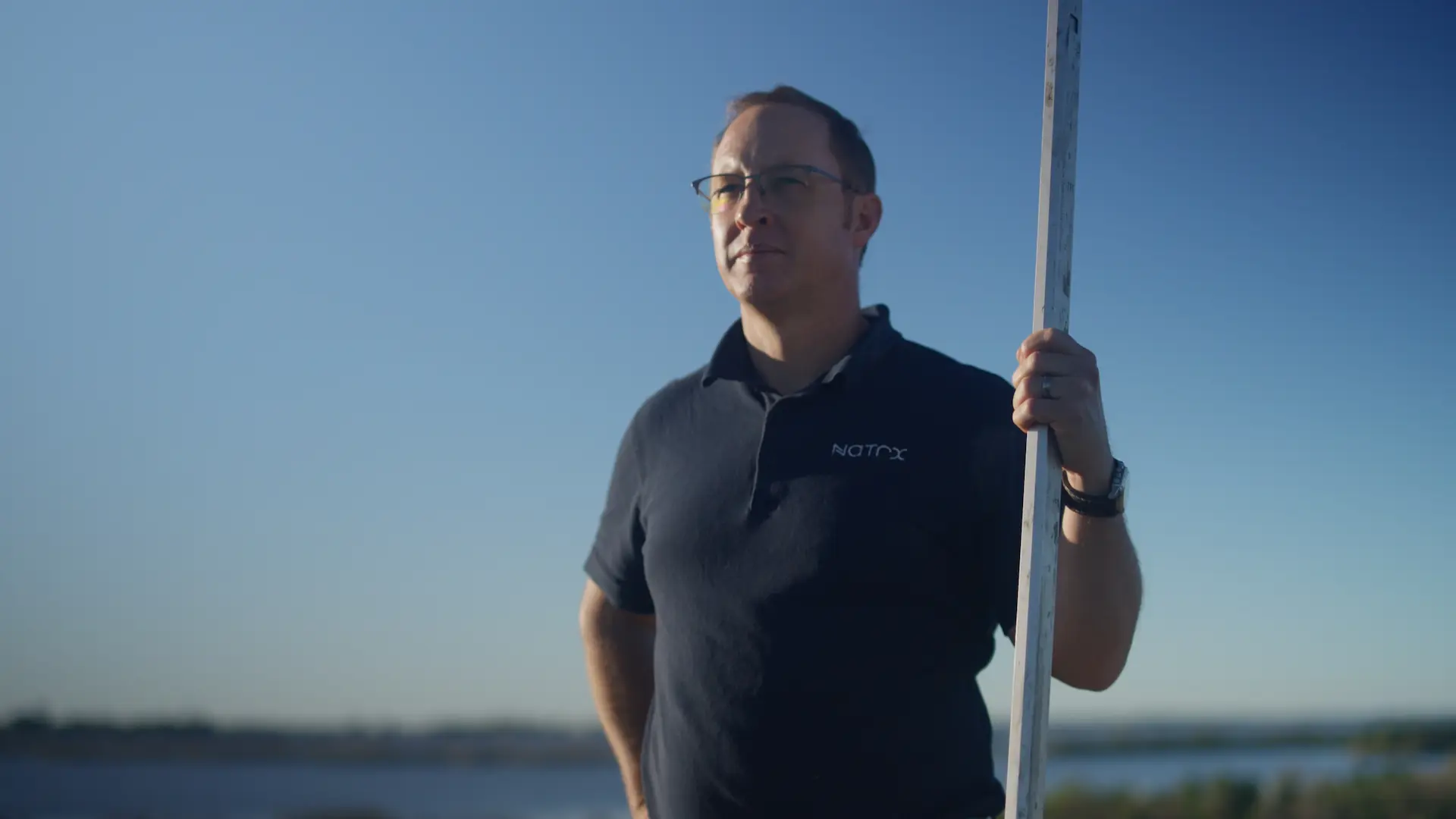 a man holding a pole near the water
